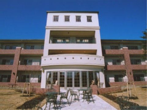 芝生エリアに挟まれた石敷きの場所に置かれているガーデンチェア