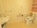 洗面台を完備したトイレ。洋式トイレの近くには手すりが設置されている。
