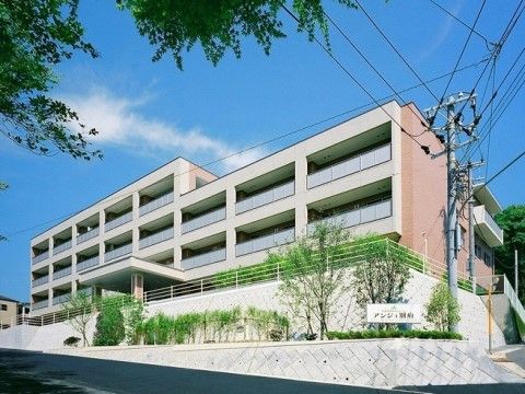 坂道の前にある敷地に建っている一部４階建ての施設全体外観