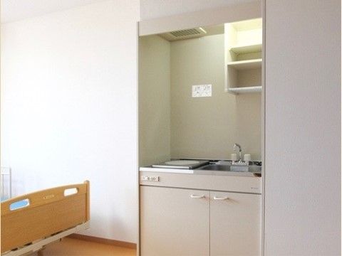 居室にはミニキッチンが設置されている。流し台、加熱設備、排気ダクト、扉付きの収納スペースが備わっている。