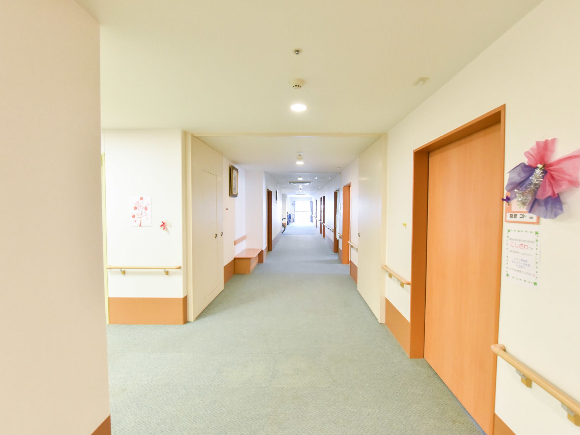 廊下から各部屋へスライド式のドアがつけられており、他の壁には手すりがついている。壁の所々に飾りや額がかかっているのが見える。