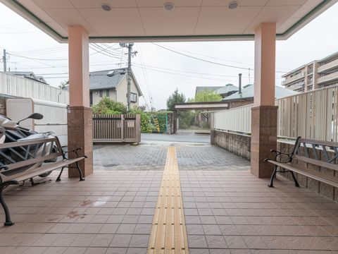 両側にガーデンベンチが置かれている、ダウンライトがついたひさし