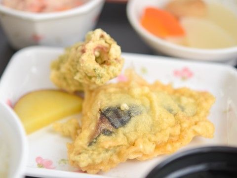 ちくわと魚の切り身を挙げたメニュー。奥には野菜の煮物のような小鉢も見える。