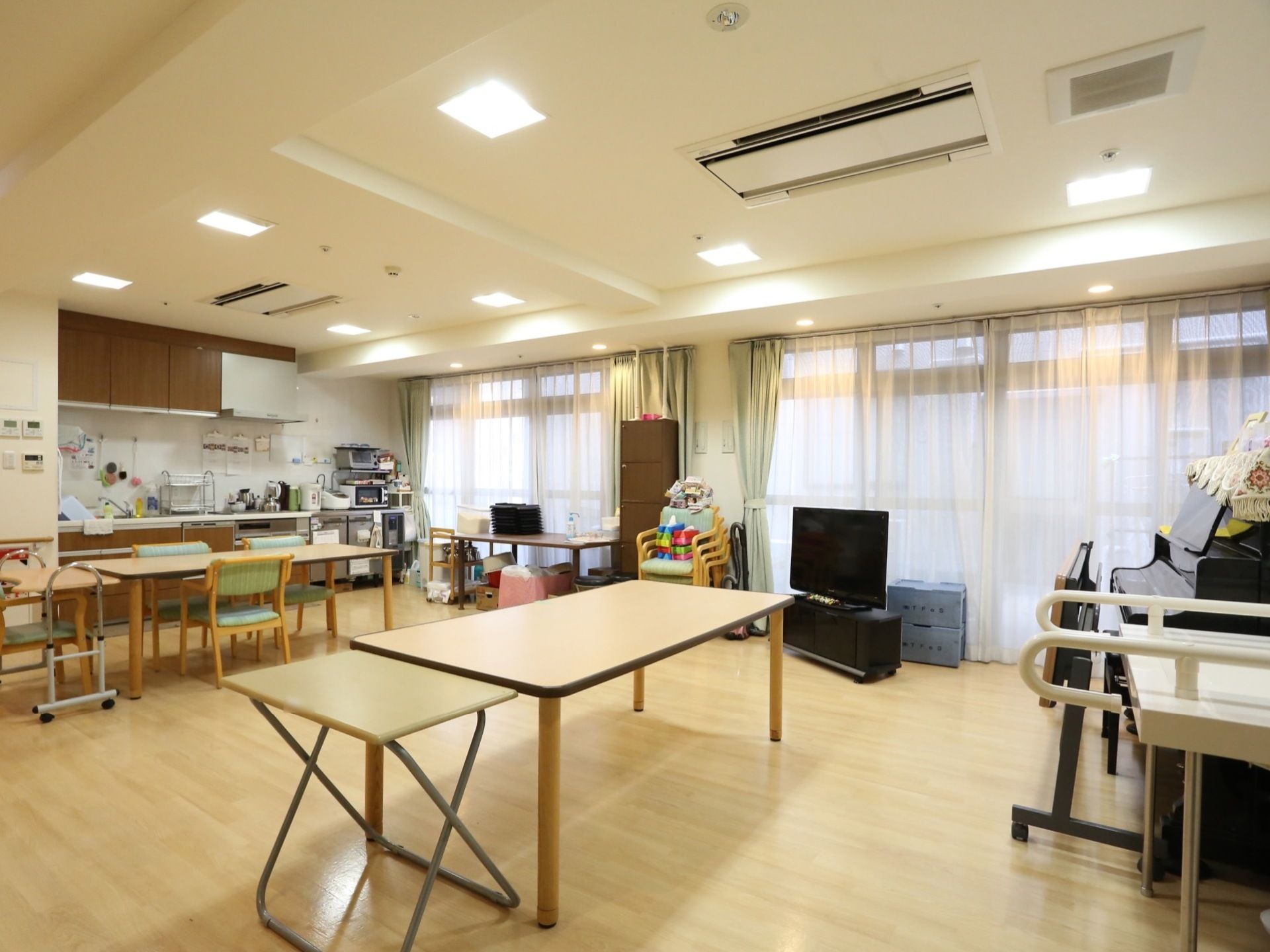 共有スペース広々としており、部屋の奥にはキッチンが完備されている。窓際には、大きなテレビが設置されている。