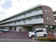 大きな３階建ての施設になっている。白と落ち着いたブラウンの壁になっており、広い駐車場も設置されている。
