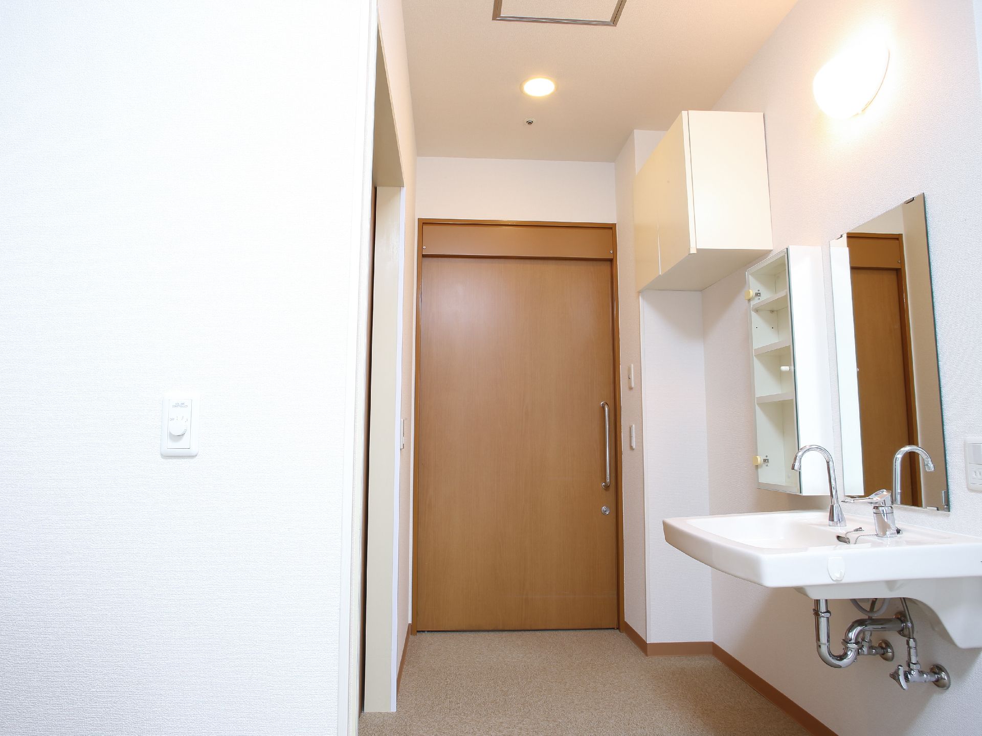 部屋に入るとすぐ左に洗面台がある。ガラス扉の付いた小さな棚と吊り戸棚がある。水道はレバー式で蛇口は少し首長のタイプになっている。