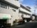 閑静な住宅地に建っている３階建ての施設。青空を背景に建つ白一色の建物は、清潔なイメージを感じさせてくれる。