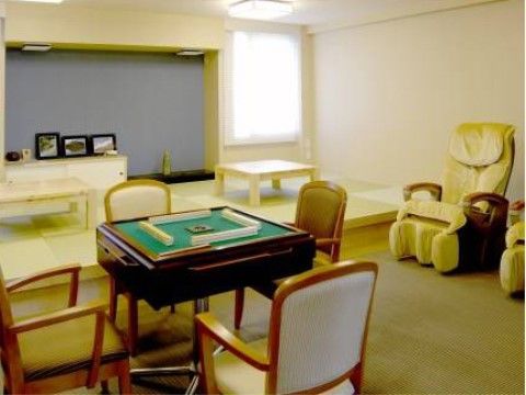 麻雀パイが並べられている麻雀卓と、壁際に置かれたマッサージチェア