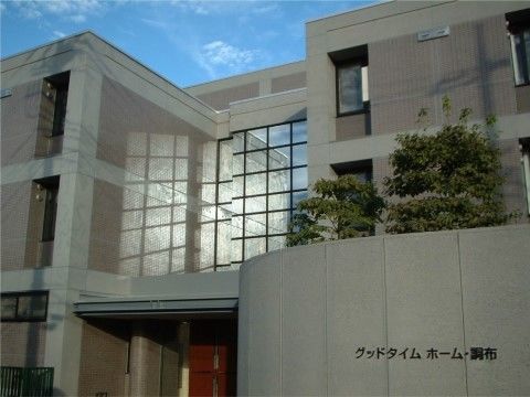 ３階建てのデザイナーズマンションのような、タイルと石柱を組み合わせた造りの建物である。建物の脇には木が植えられている。