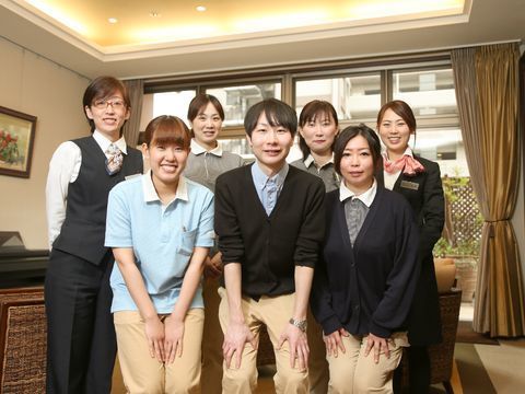 ユニフォームなどを着て、並んで集合写真に収まっているスタッフ