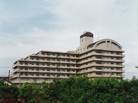 木々の向こうに見える、屋根の一部が半円形になっている施設外観