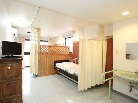 「板橋やすらぎの園 2号館」の居室（相部屋）。間仕切りでプライバシーを確保できる。
