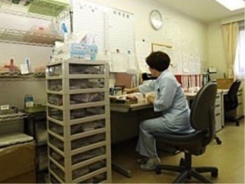 月間予定が書かれたホワイトボードが壁に設置されている事務室