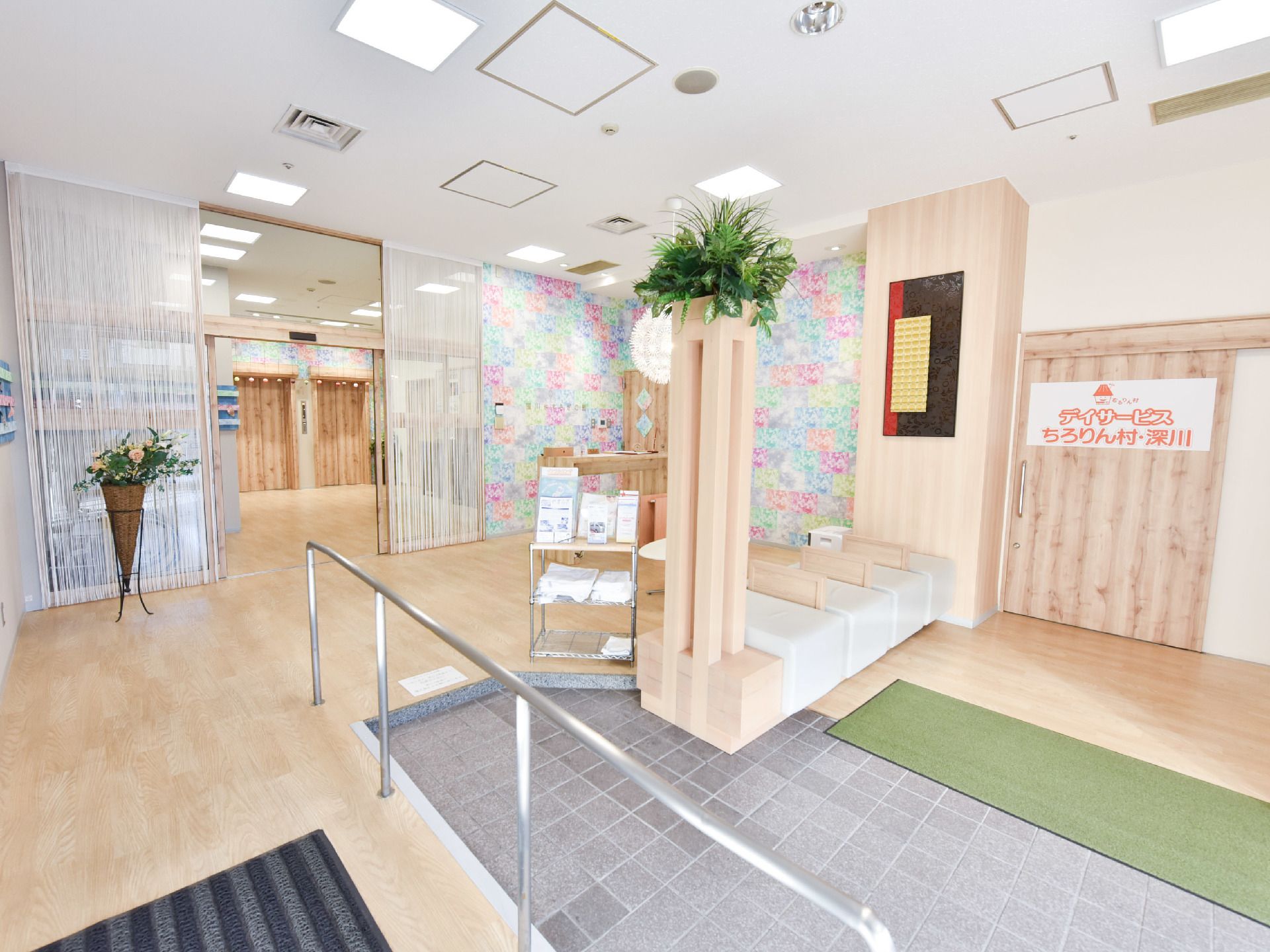 木目に多彩な色を取り入れた玄関ロビーはとても明るい。また深川の情景を盛り込んだスペースとなっている。