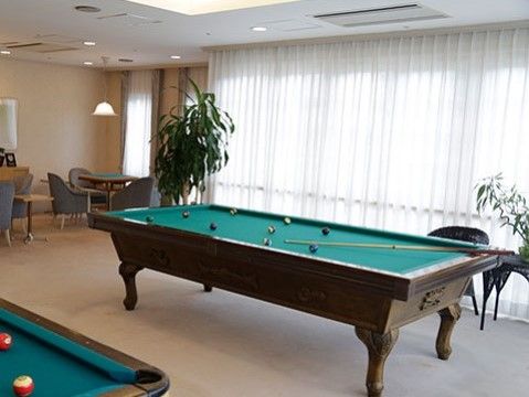 落ち着いたベージュの部屋にはビリヤード台や麻雀卓が用意されている。大きな窓から光が差し込む明るい部屋である。