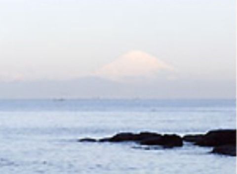 晴れた空の先に大きな山が見える。天気の良い日には、海辺を散歩しながら広大な自然を見ることが可能である。