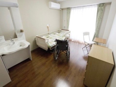 白を基調とした清潔感ある居室はベッドを入れても車椅子でご移動できる十分なスペースがあり、快適にお過ごしいただける環境である。
