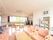 薄いオレンジ色の床の部屋にたくさんの椅子やテーブルが置いてある。腰高窓に赤いカーテンが掛けてある。