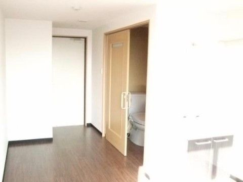 居室の入り口付近。廊下と居室をつなぐドアは白く、圧迫感が少ない。横開きのドアがついたトイレも完備されている。