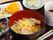 黒トレイの上にラーメンやシュウマイ、きゅうりの酢の物などが並べられており、デザート用にカットフルーツも用意されている。