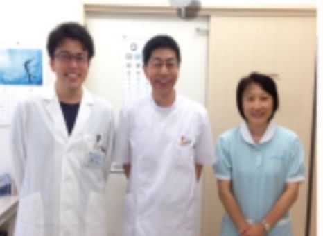 白衣の男性２人と水色の制服を着た看護スタッフの女性。
