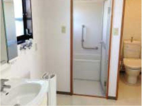 白を基調とした清潔感のある洗面所に面して、浴室やトイレが配置されている。洗面所と浴室には外光の入る小さな窓がある。