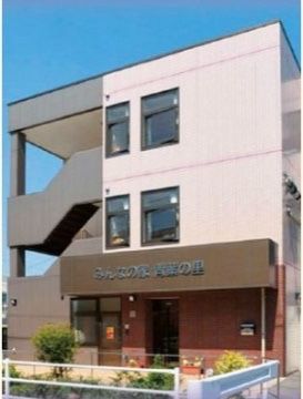 屋根がついた外階段が設置されている３階建ての施設外観