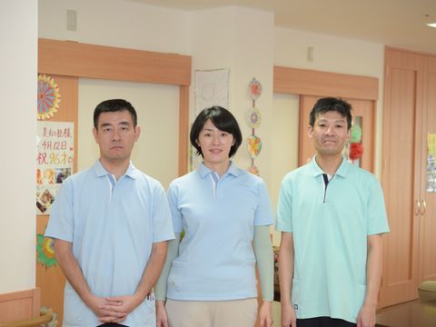 廊下に並んで立ってこちらを見ている男女３名のスタッフ