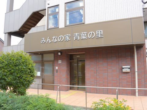 エントランスのひさしには、併設の小規模多機能型居宅サービスの事業名が掲げられている。茶色のレンガ造がシックな面持ちを提供している。
