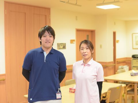 ユニフォームを着て並んでいる男女１名ずつのスタッフ
