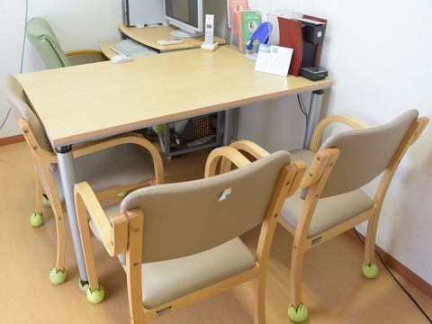 カットされたテニスボールが脚にはめ込まれた椅子がある談話室