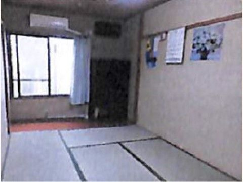 畳が敷かれた和室タイプのシンプルな居室である。エアコンが完備されており、窓にはカーテンが取り付けられている。