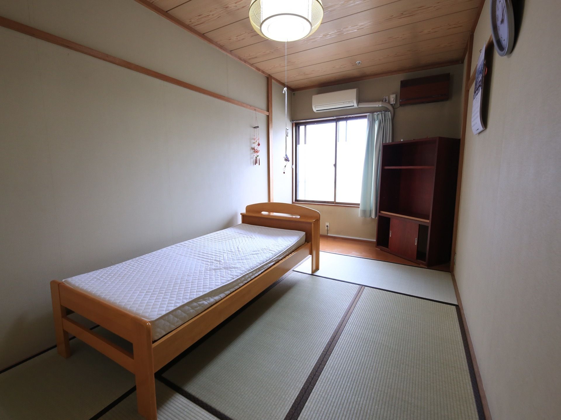 居室は茶色い縁の畳が敷かれた和室である。窓際には板の間があり、エアコンが取りつけられている。収納棚を置くスペースもある。