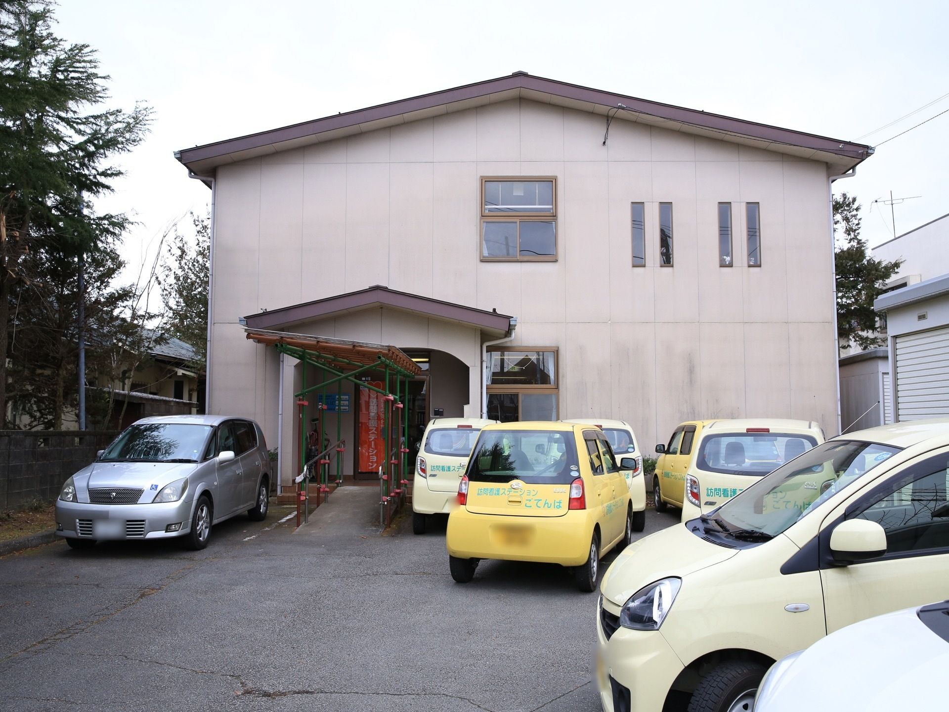 建物の前には、複数台駐車可能なスペースが取られている。駐車場から建物へのアプローチはスロープである。