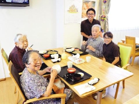 大きな背もたれのある椅子に座ってお食事を召し上がっている入居者様たち