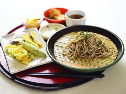 円形のお盆の上に載っている、ざるそばや天ぷらなどの器