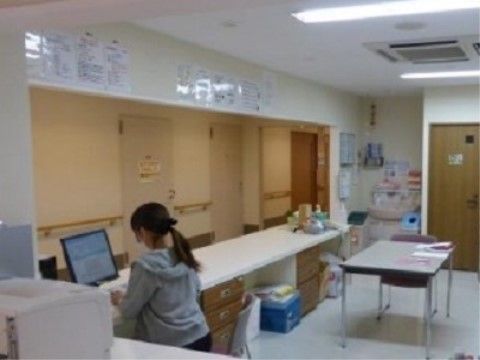 広いスタッフルームでパソコン作業をする女性スタッフ