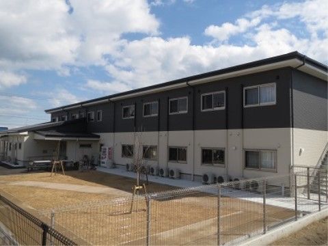 フェンスで囲まれた広い中庭があり、外階段つきの建物