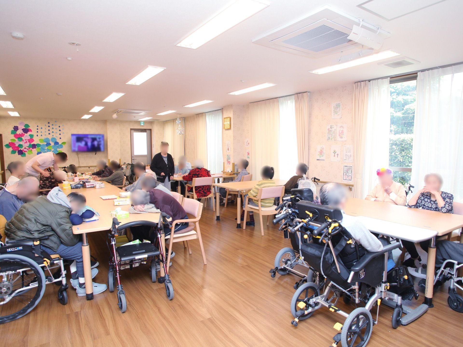 広々としたスペースがあり、車椅子のまま席に着くことができる。壁には、絵や折り紙で作られた花などが飾られている。