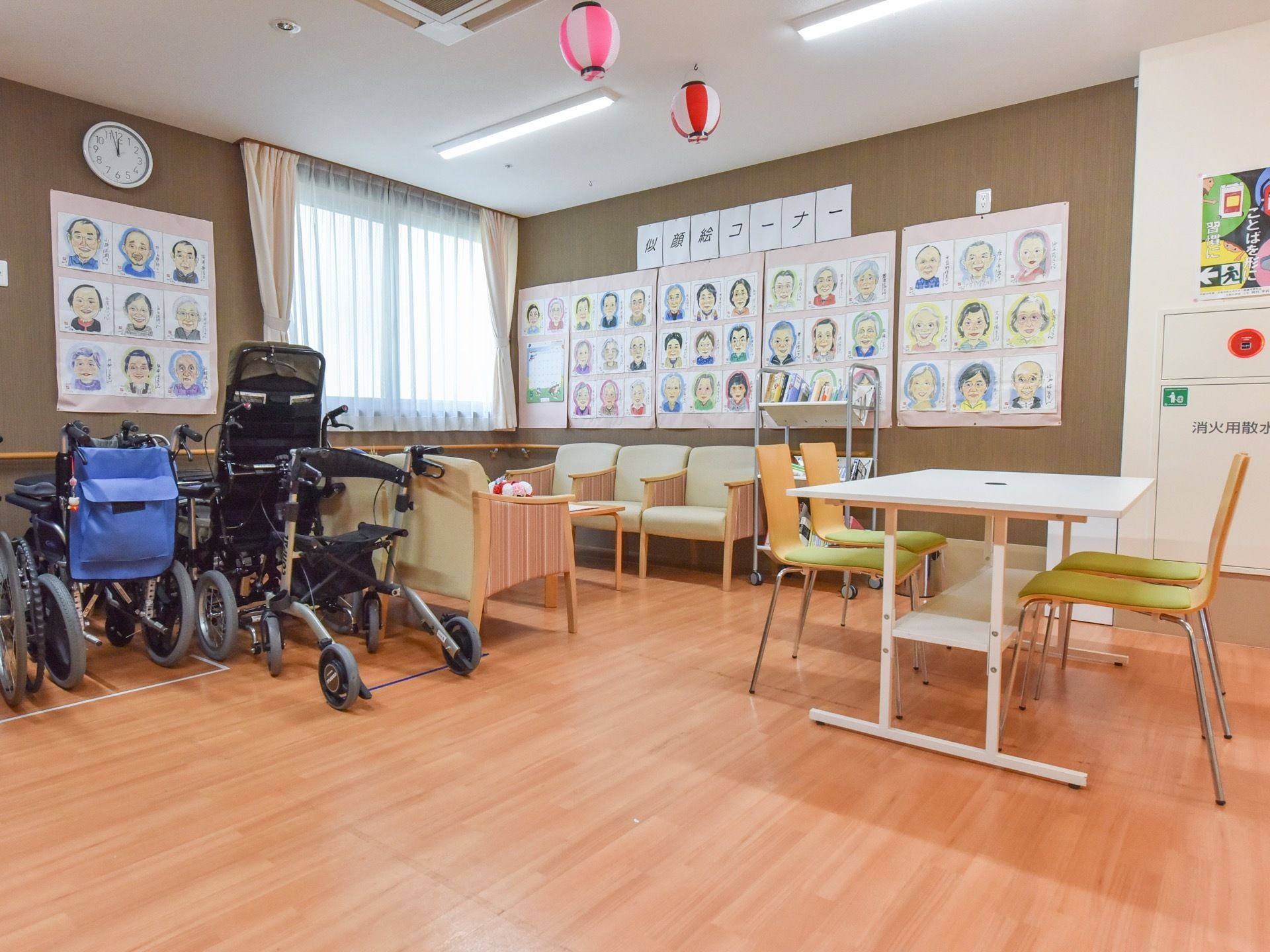 共有スペースの一角の壁には利用者様の顔の似顔絵が並べて掲示されている。食事のあとなどに座って眺めることができる。