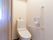 居室に設置されている個室型のトイレ。天井近くにはトイレットペーパーなどをストックするのに適した棚が設けられている。