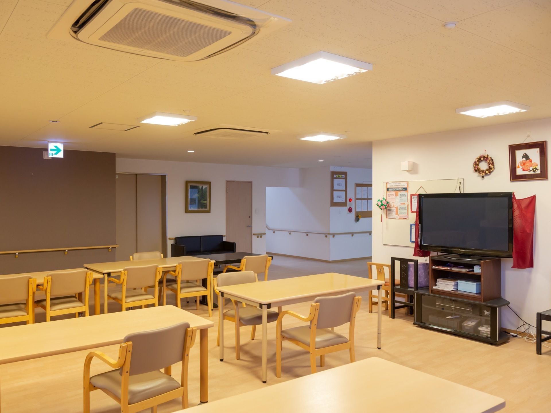 大きなテレビがあり、多数の入居者様が集まる場所に最適。廊下には手すりもあり、多くの方が利用しやすい。