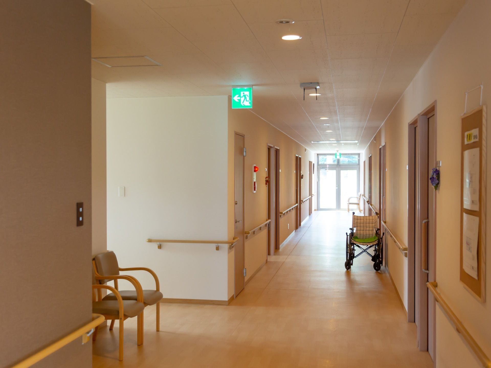 各居室へのドアと手すりが取り付けられた、光が入り明るい廊下