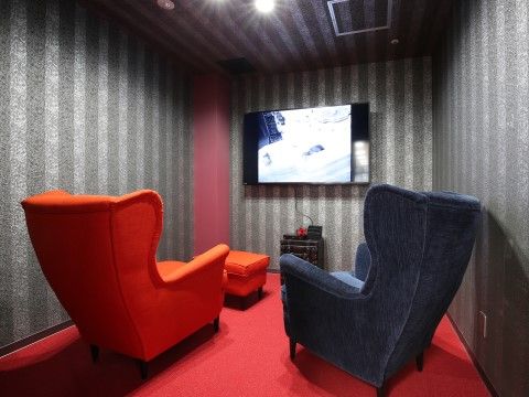 座り心地のよいソファと壁掛けの大型テレビが用意されたシアタールーム