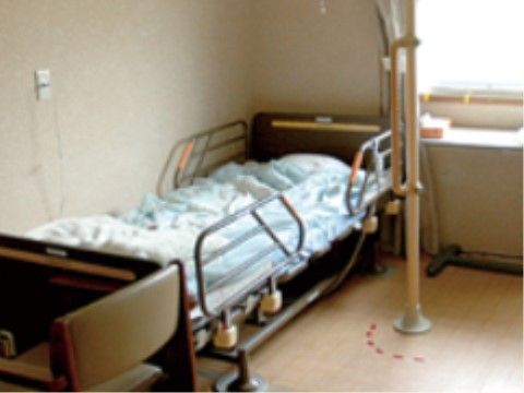 自然光も十分に取り入れられるお部屋である。ベッド外周部の保護カバーや手すり等の安全対策も配慮されている。
