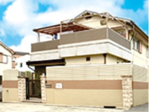 施設はベージュ色の外壁の落ち着いた雰囲気の建物である。２階建てになっており、大きなベランダが設置されている。