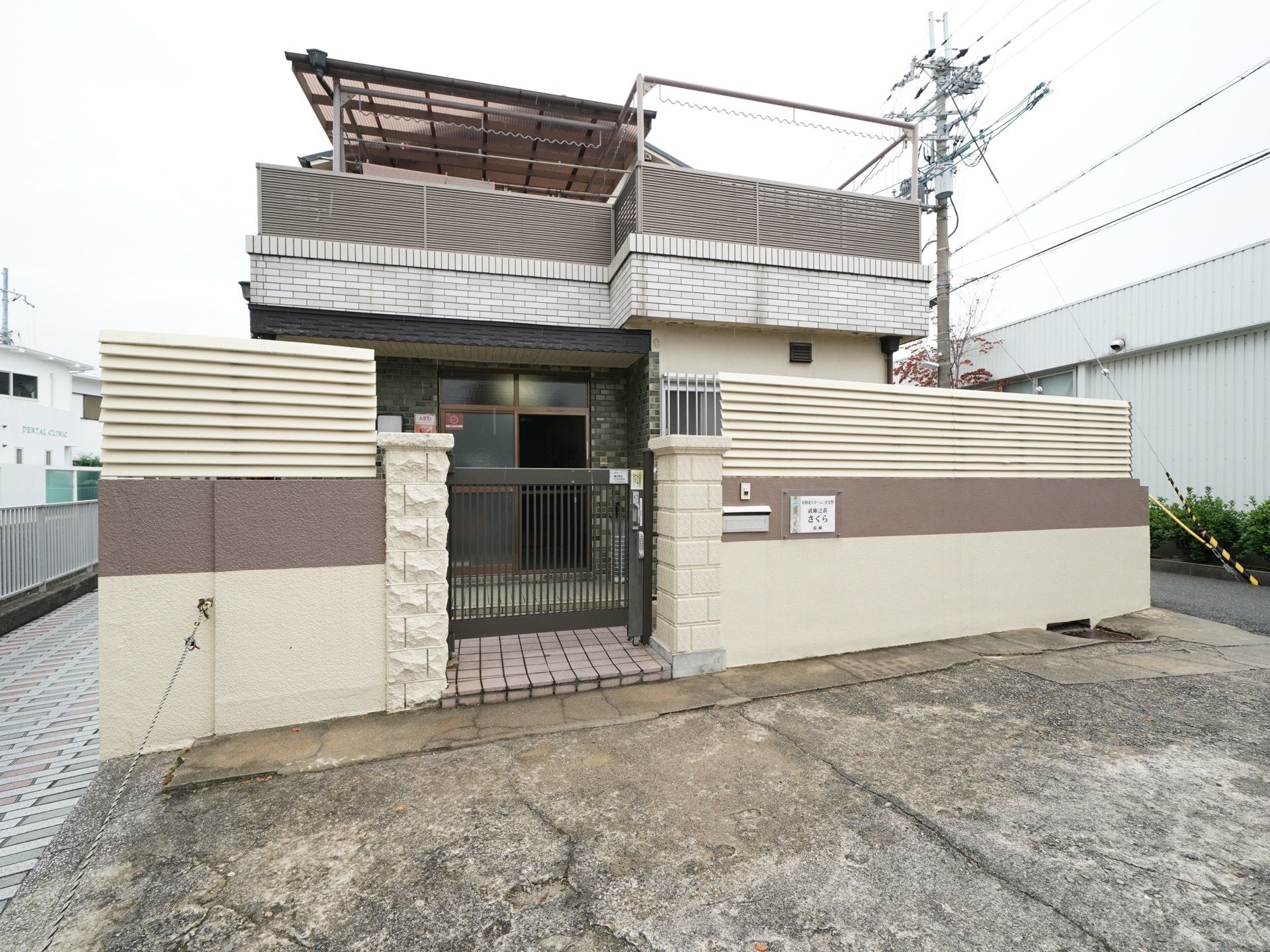 二階建ての、一般住宅のような外観で、周りをツートンカラーの壁に囲まれている。二回にベランダがあり、玄関はスライドドアである。