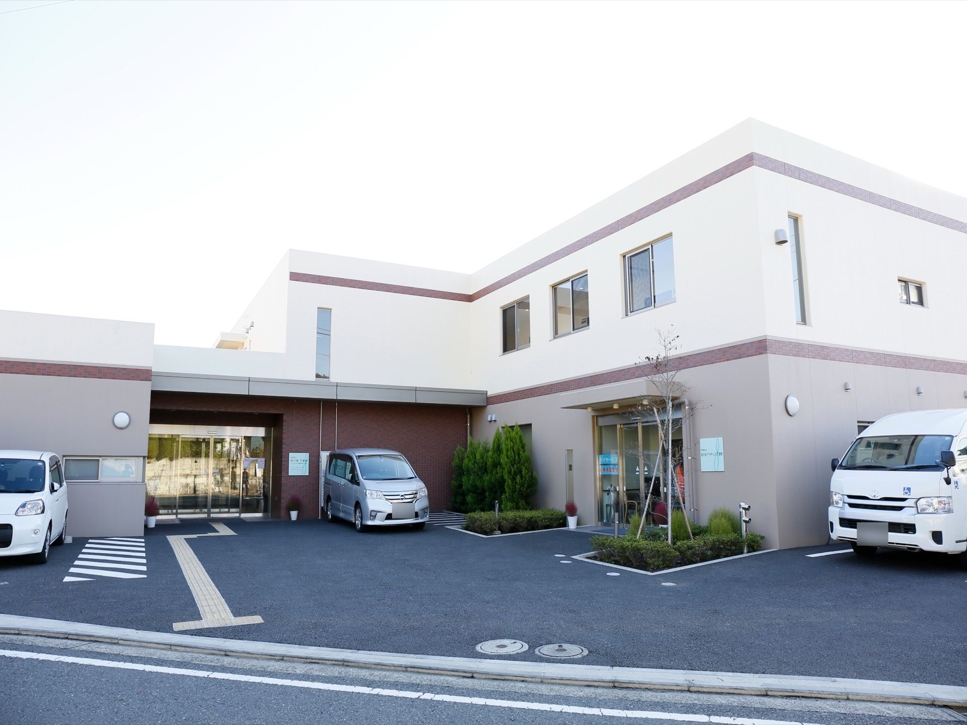 二階建ての建物で、入り口が二ヶ所付いている。周りは駐車スペースとなっており、黄色の点字ブロックがある。
