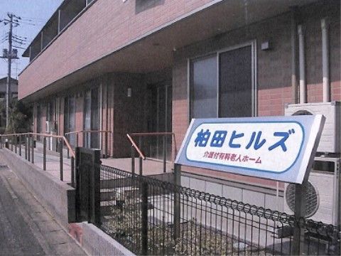 玄関に向かい長いスロープがある、二階部分が庇になった建物