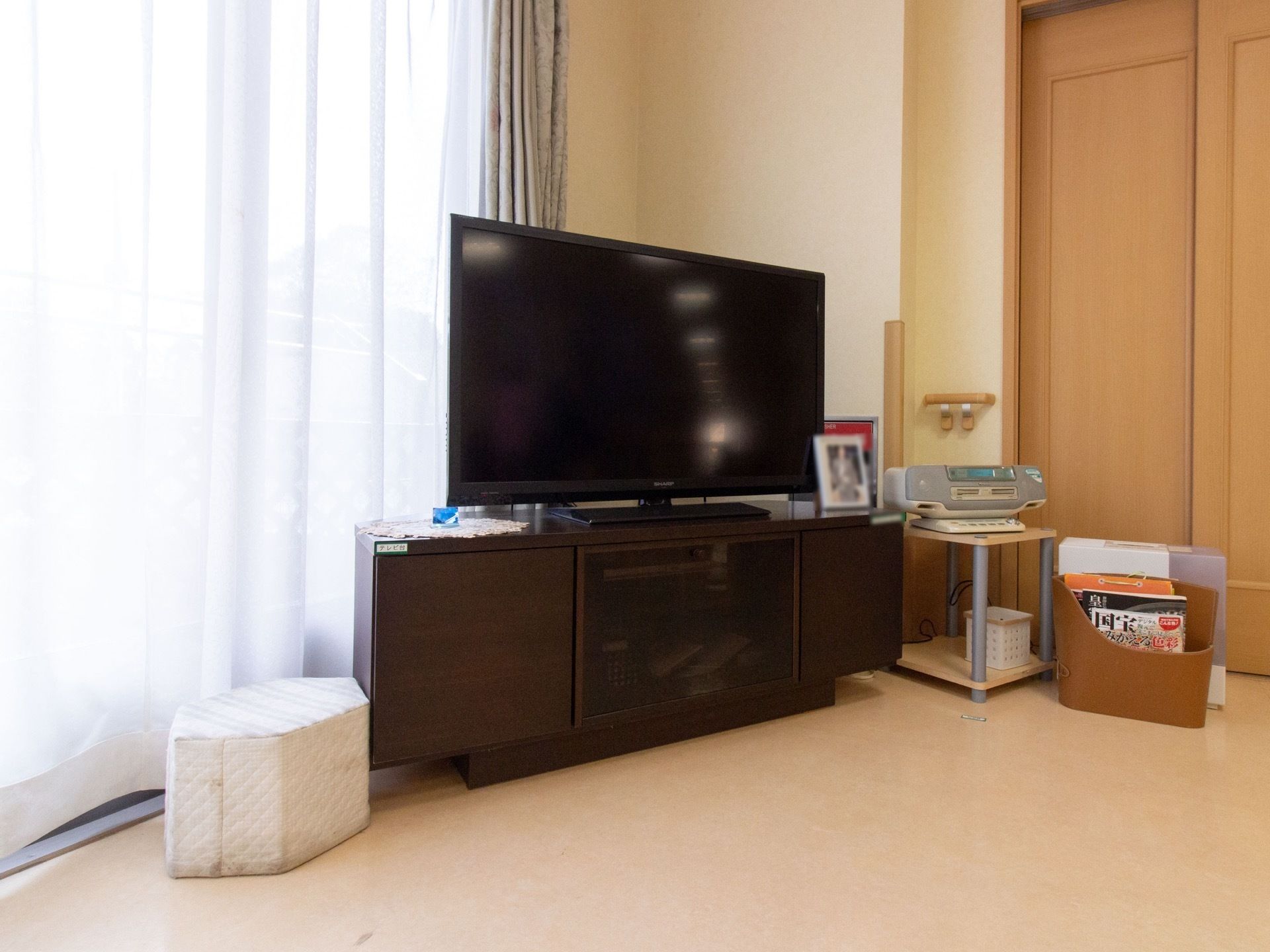 日当たりの良い窓際にテレビセットやオーディオ機器が斜めに置かれ、部屋のどこからでも見やすいように配置されている。